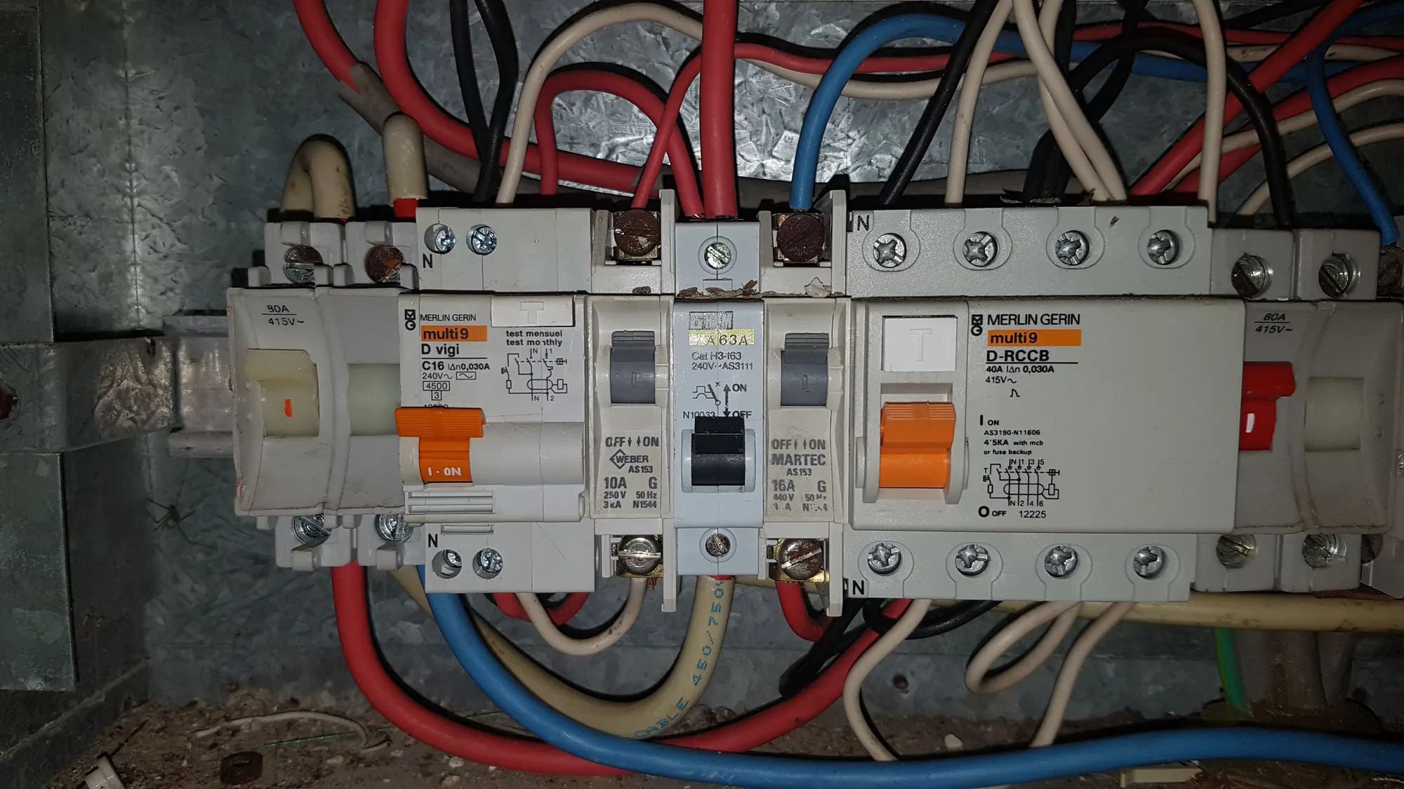 Inside an open switchboard showing existing wiring before an upgrade