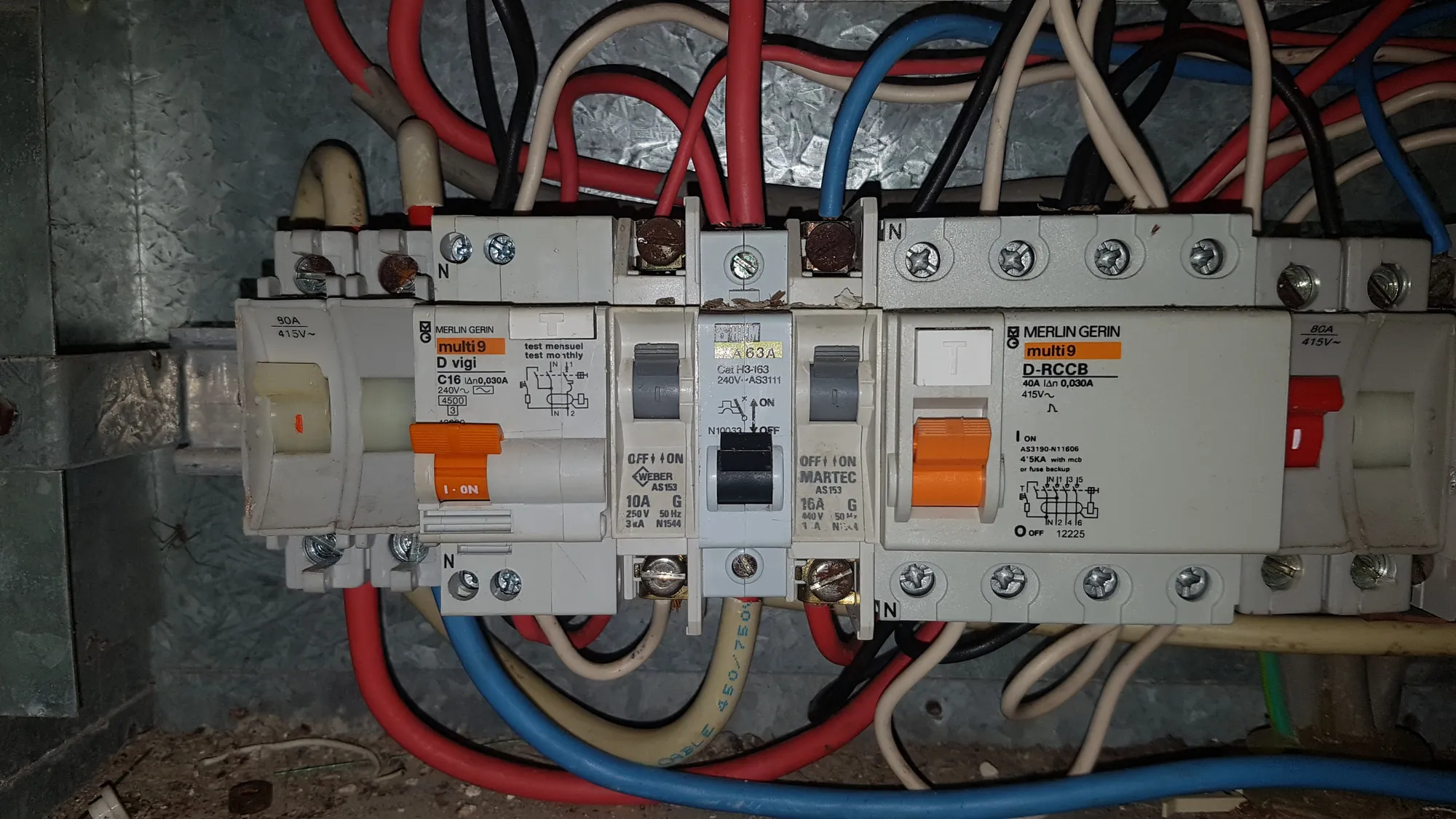 Inside an open switchboard showing existing wiring before an upgrade