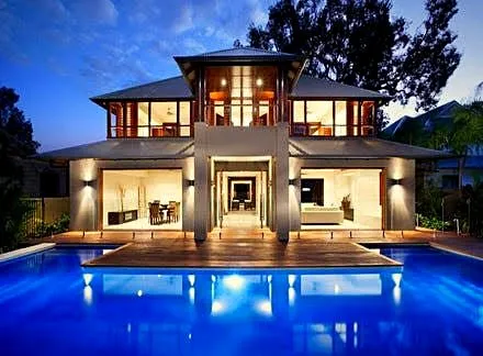 A Port Douglas home lit at dusk with the pool lit blue