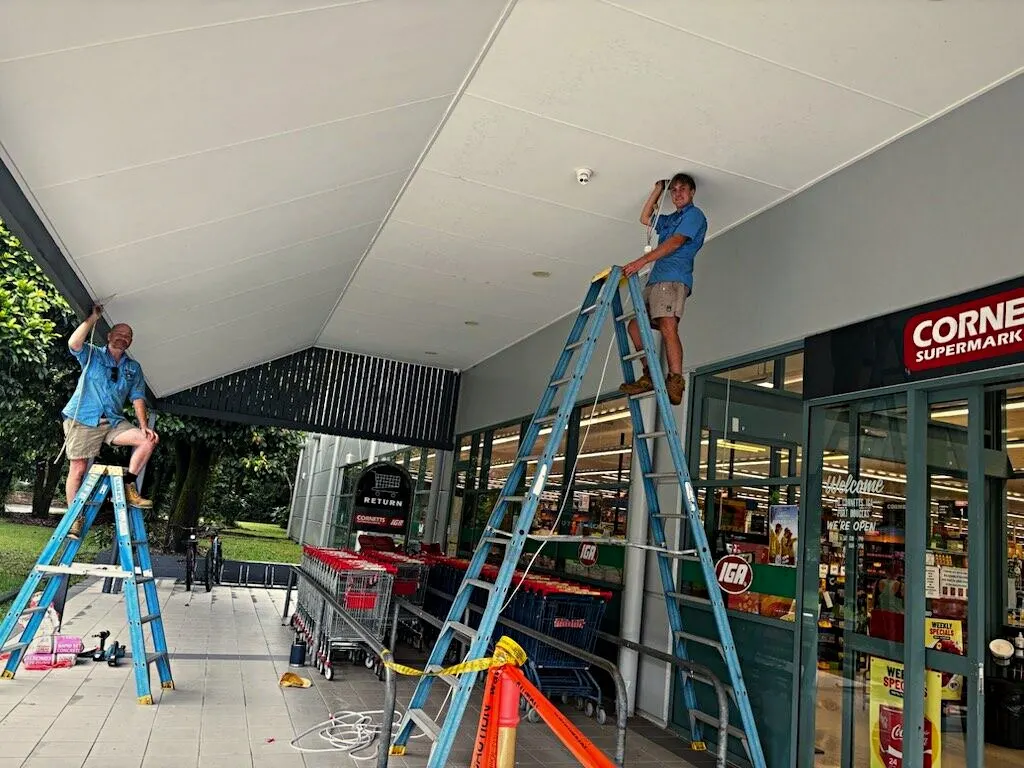 BH Electrics apprentices on ladders outside Cornetts IGA, Port Douglas