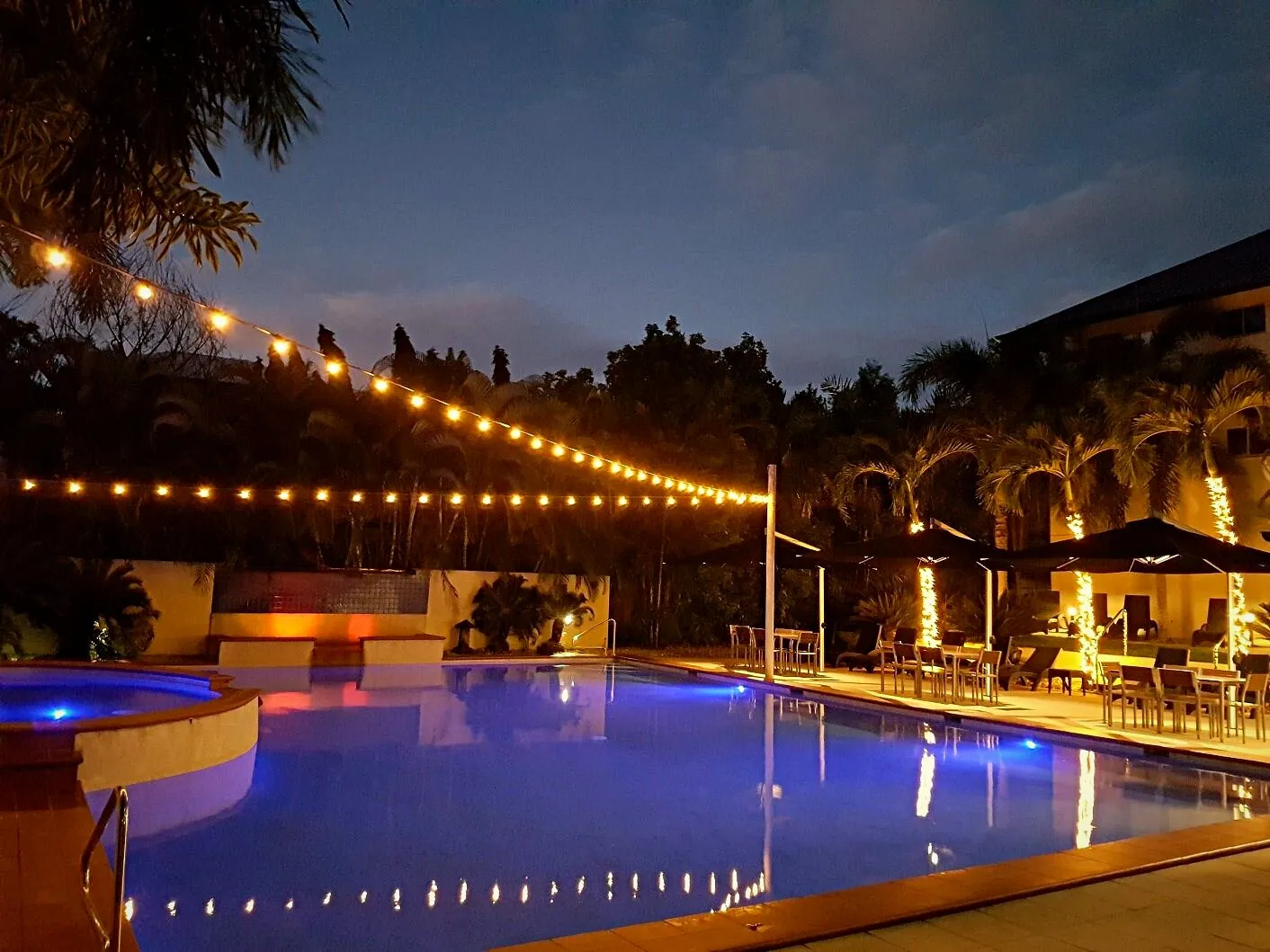 A Port Douglas resort pool lit at dusk