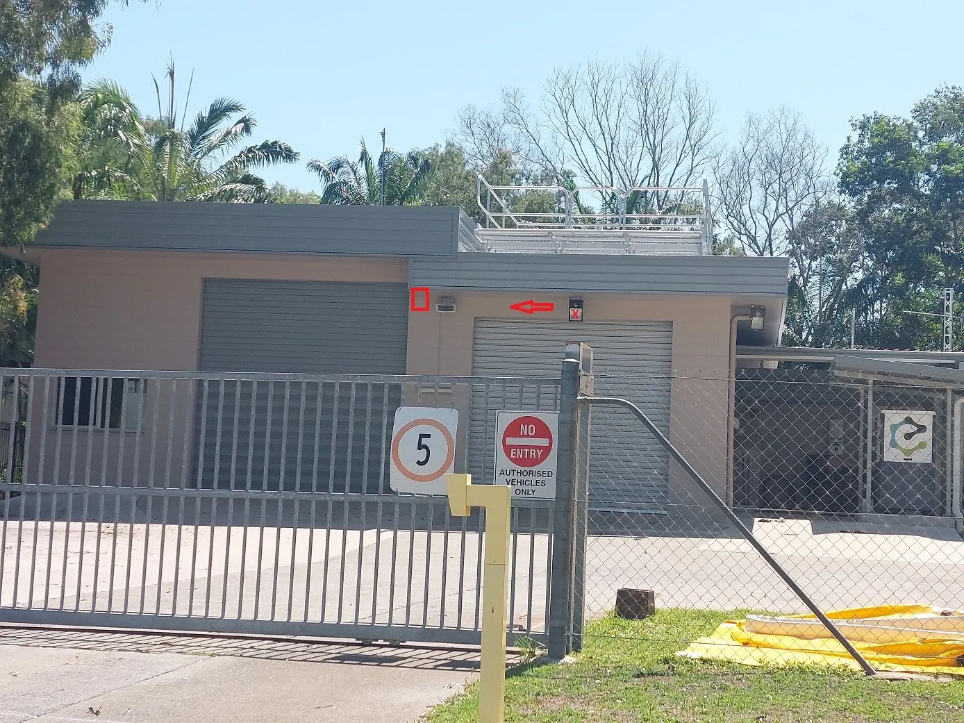 A commercial shed with roller doors and a fenced yard, power and lighting run through