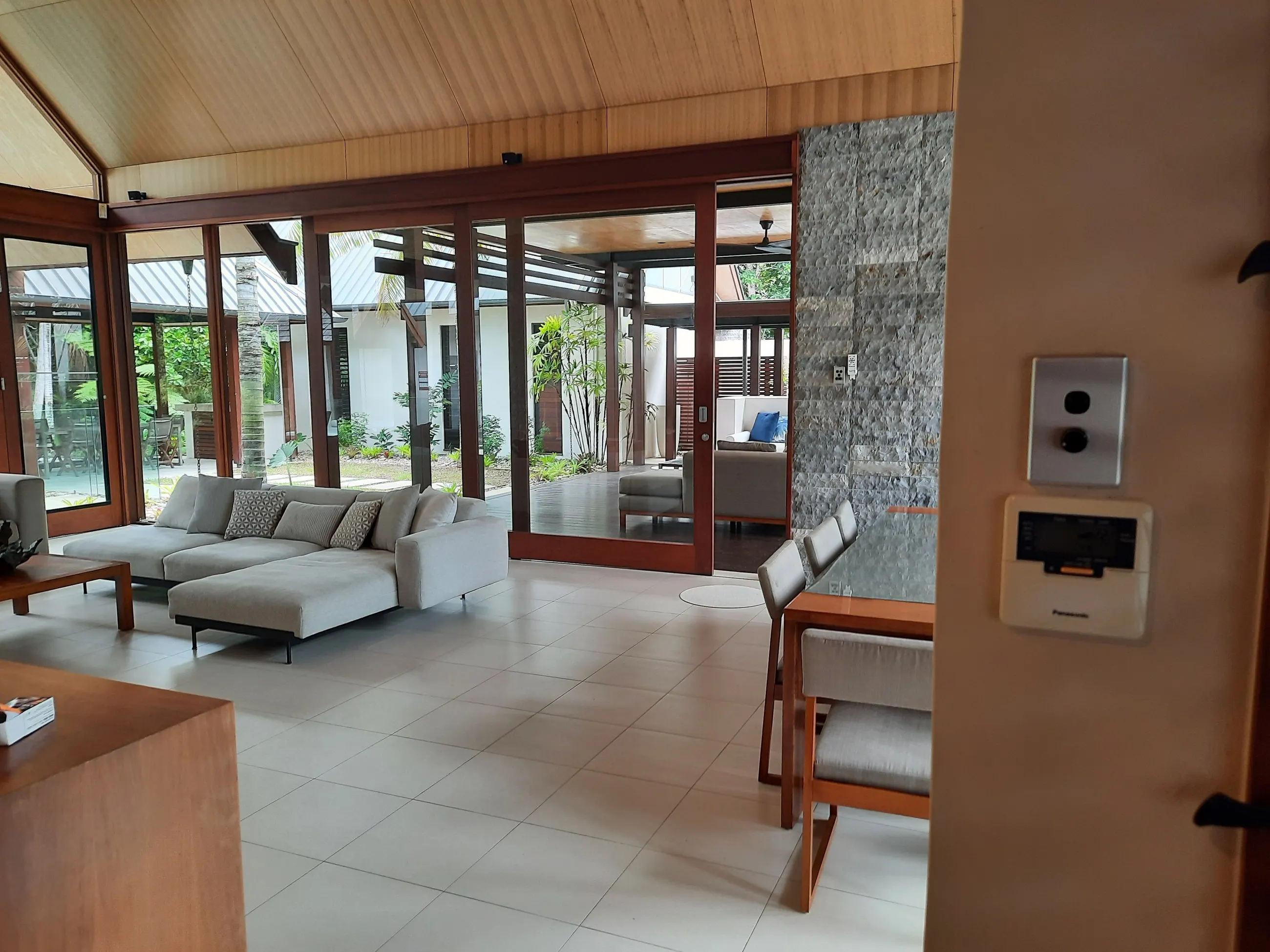 Open plan living with a timber-lined ceiling, ceiling fan and power points on the rear wall