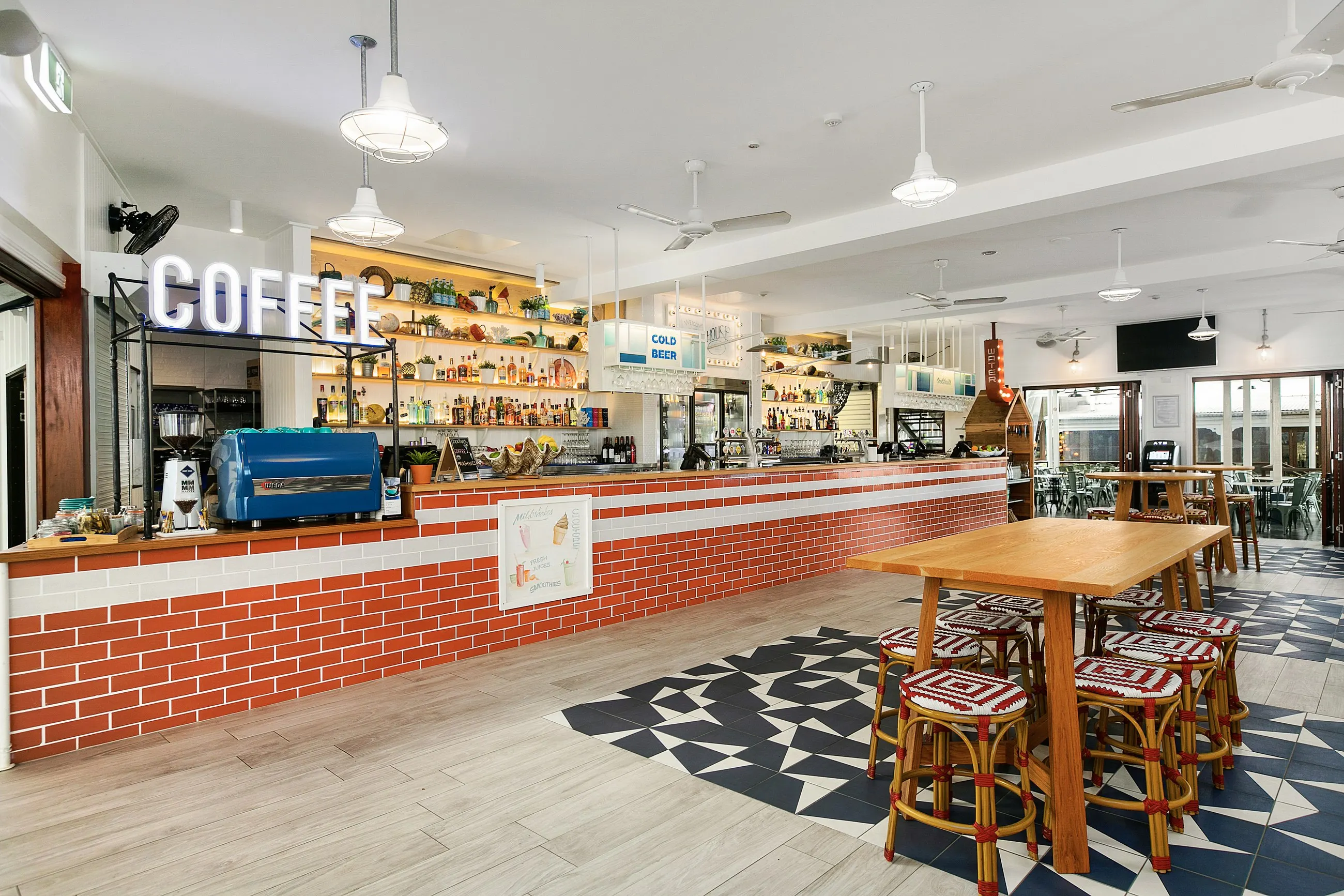 A finished cafe fit-out, pendant lighting over the counter and the coffee sign lit