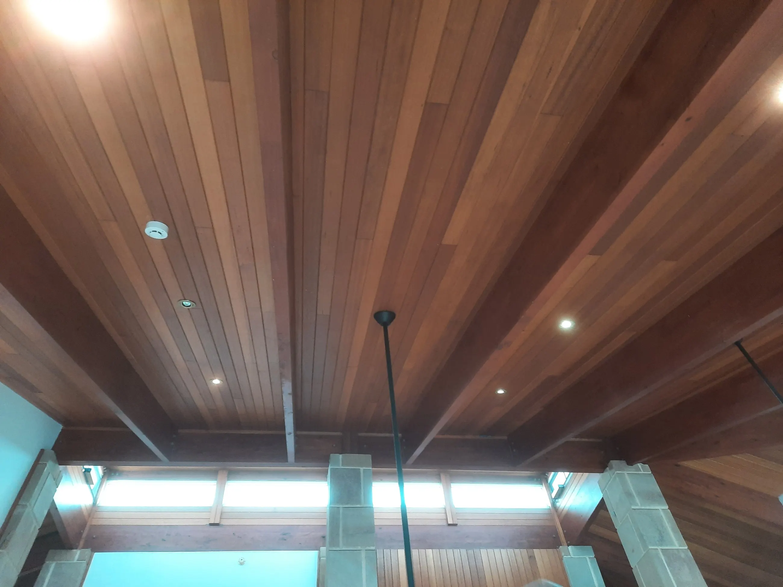 A run of downlights set into a timber-lined ceiling
