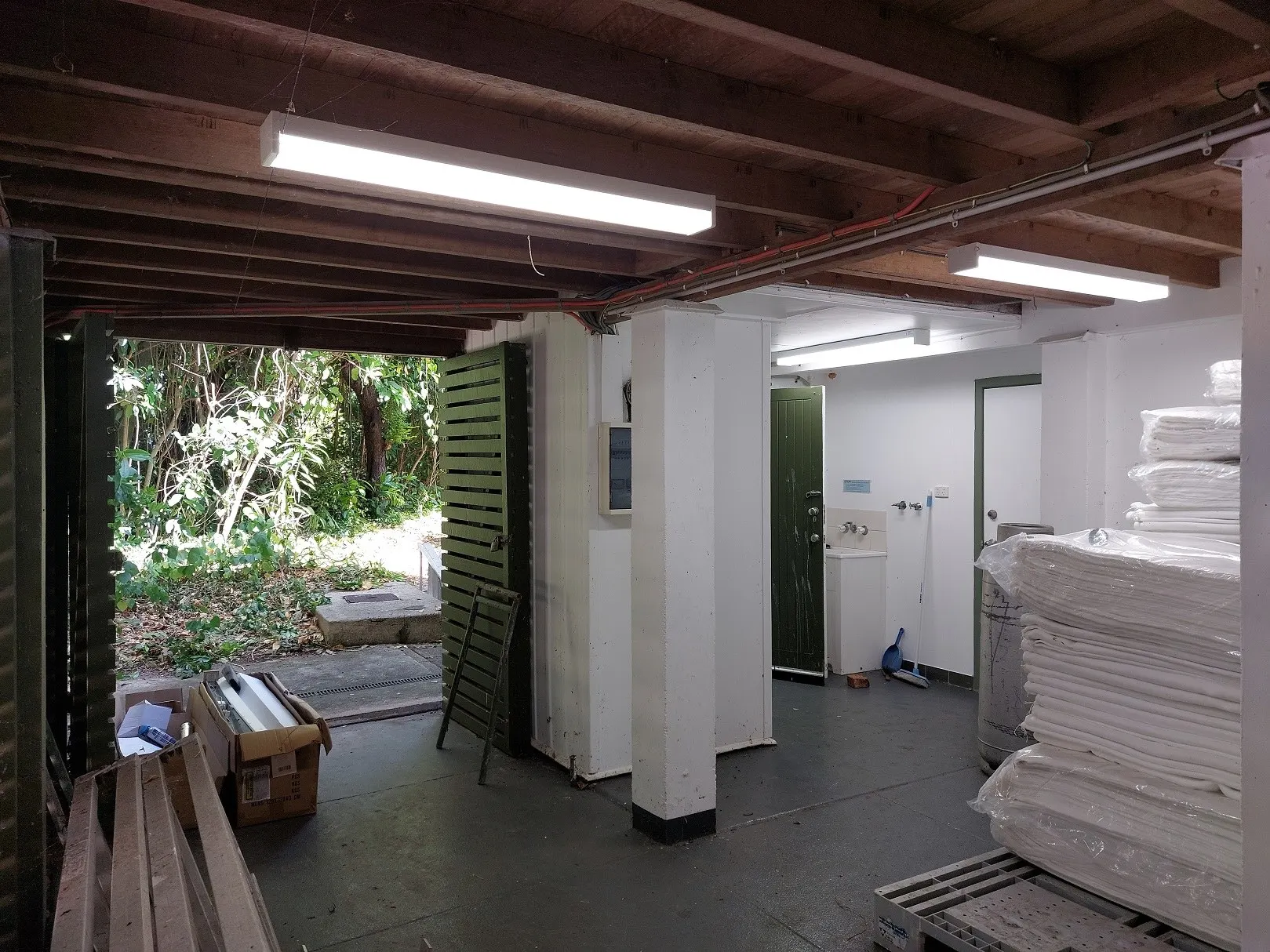 An under-house space stripped back to the joists, new battens lit overhead