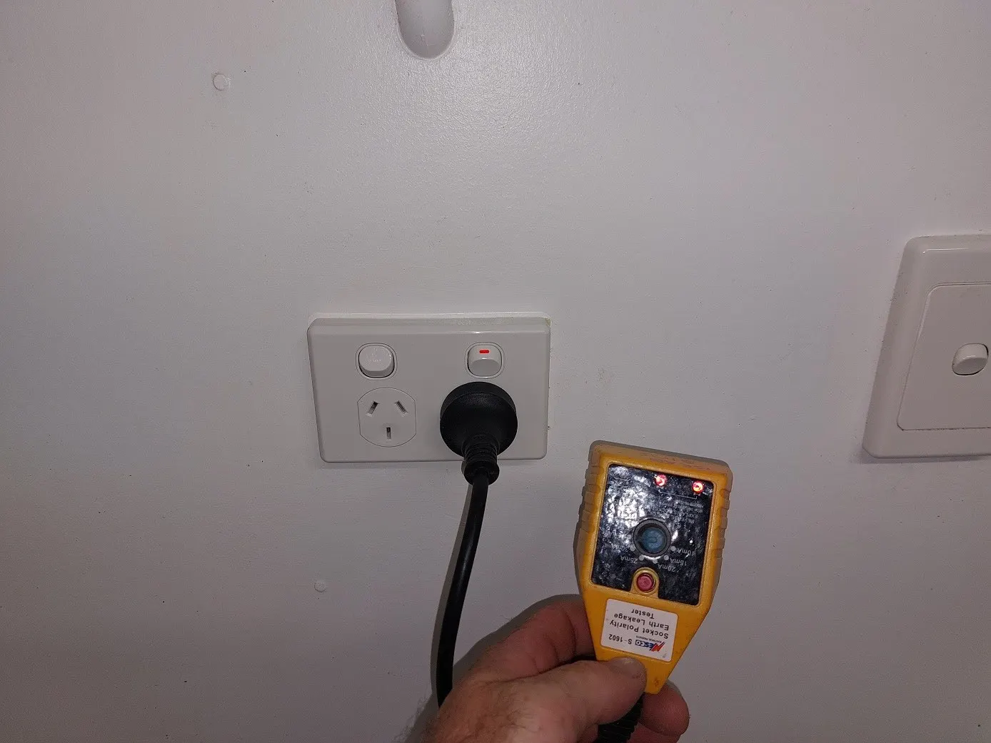 A socket tester plugged into a newly installed double power point, reading correct