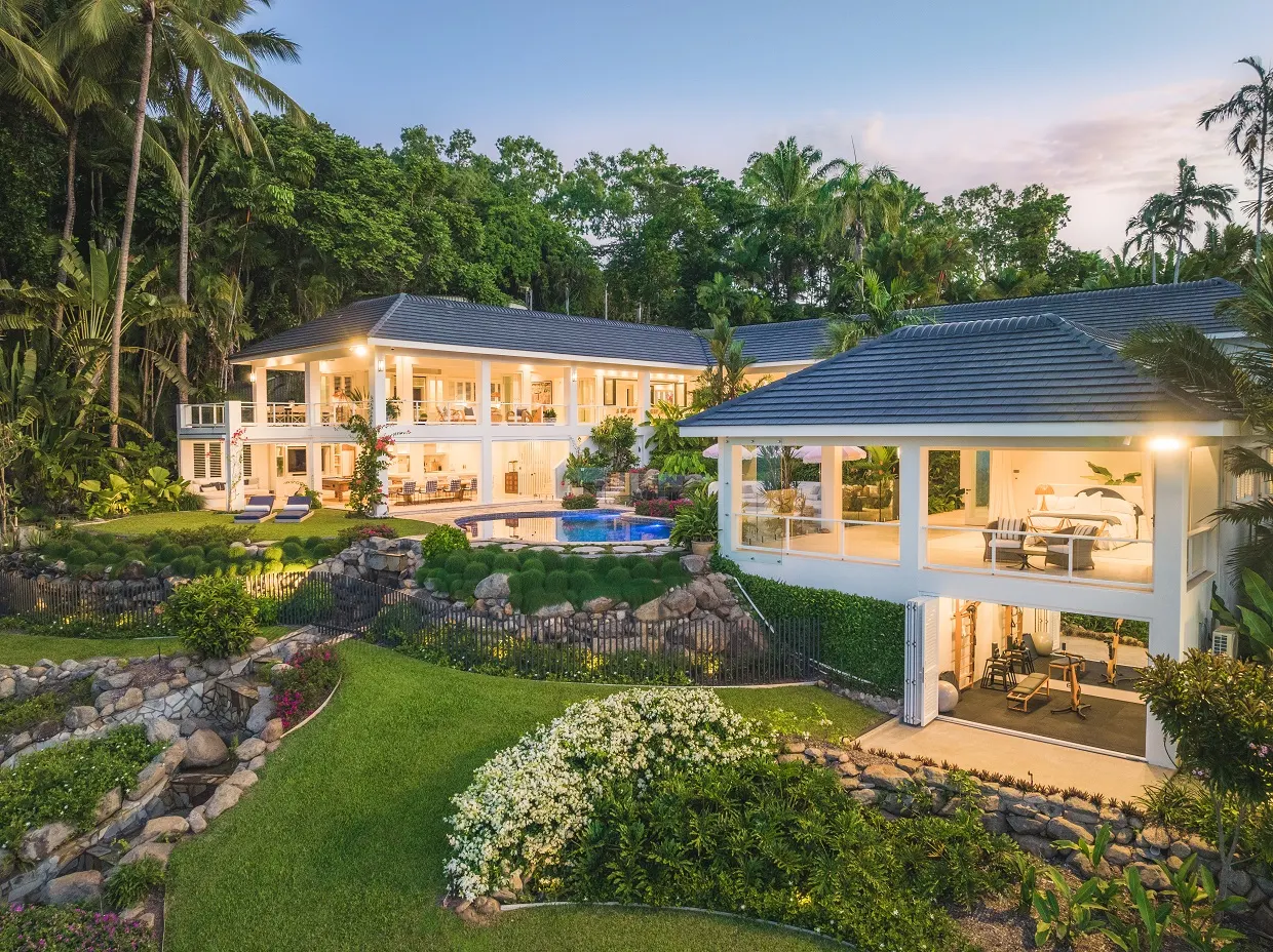 A private Port Douglas home after a major refurbishment, pool and gardens lit at dusk