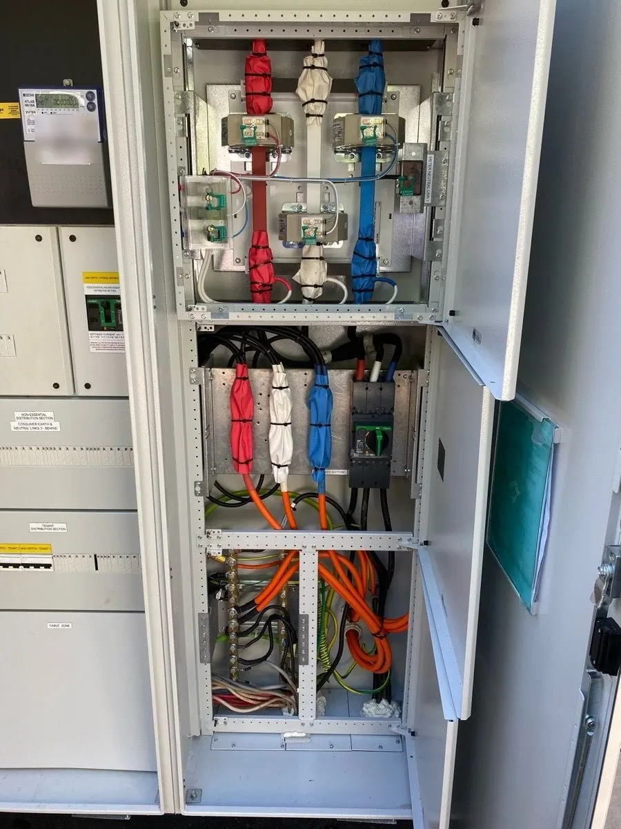 The new main switchboard at Mossman Resort Holiday Villas open, CT metering at the top and the main switch and submains below, every section labelled