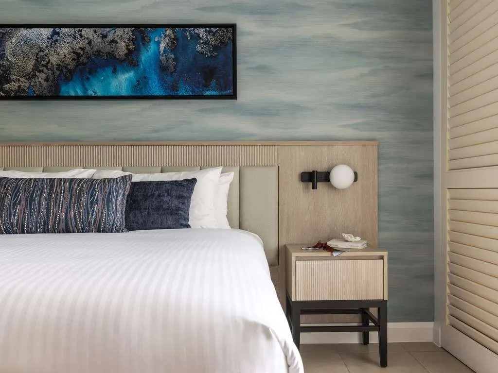 A refurbished bedroom at Peppers Beach Club & Spa, Palm Cove, a wall reading light beside the bedhead