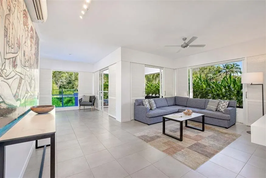 A refurbished apartment at Peppers Beach Club, Port Douglas: track lighting, a ceiling fan and shutters open to the garden