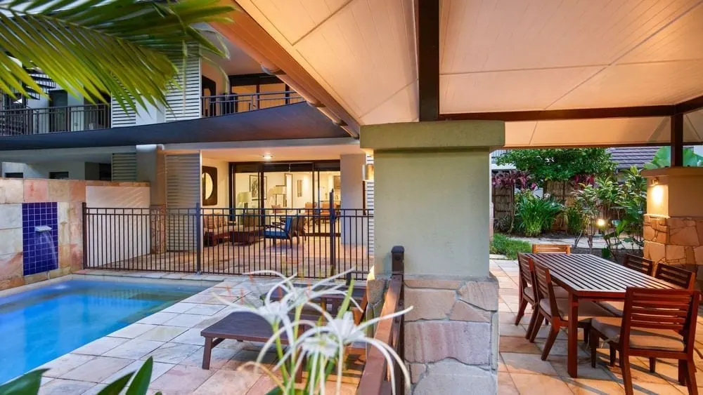 A Pullman Sea Temple villa courtyard with its private plunge pool, wall lights and outdoor dining